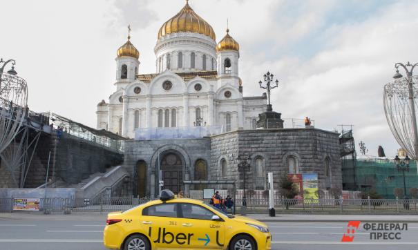 Водитель такси ожидает пассажира около православного храма