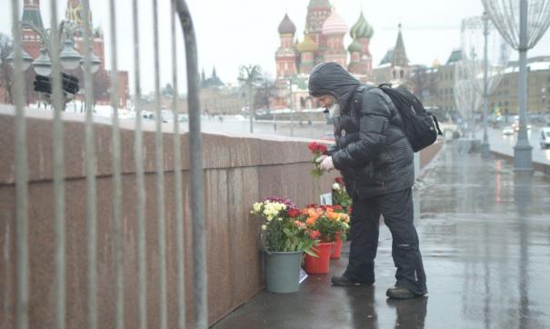 Люди несут цветы к мемориалу Немцова