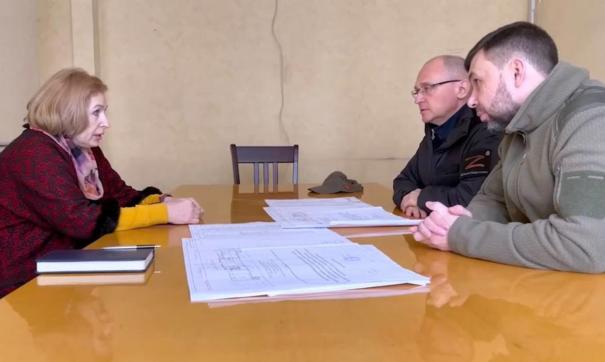 Денис Пушилин и Сергей Кириенко сидят за столом и разговаривают с женщиной
