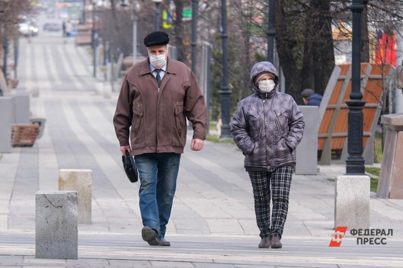 Пожилые люди в масках идут по городу
