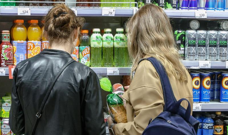 люди выбирают газировку в магазине