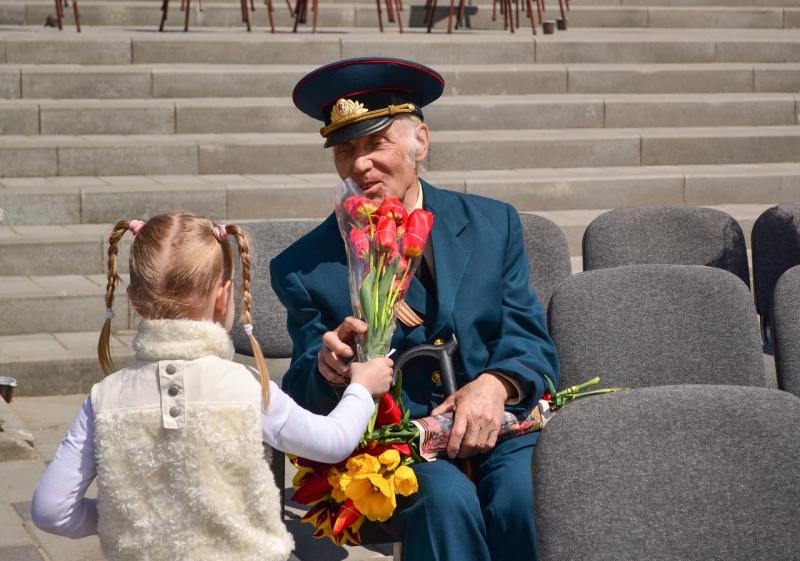 Девочка дарит цветы ветерану