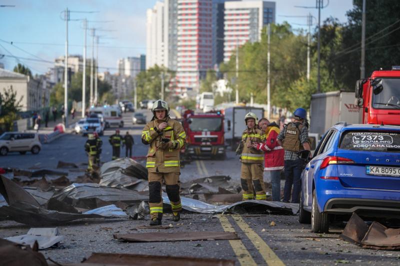 Пожарные на фоне разрушенных частей здания в Киеве