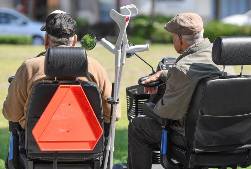 пожилые мужчины в инвалидных креслах