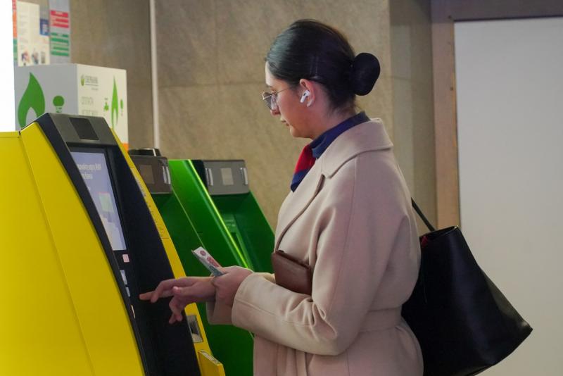 девушка пользуется банкоматом