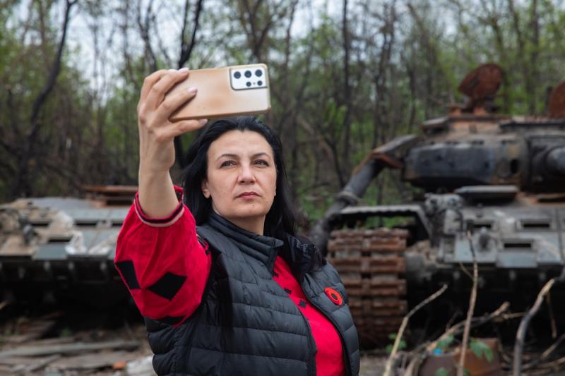 украинка фотографируется у сожженного русского танка