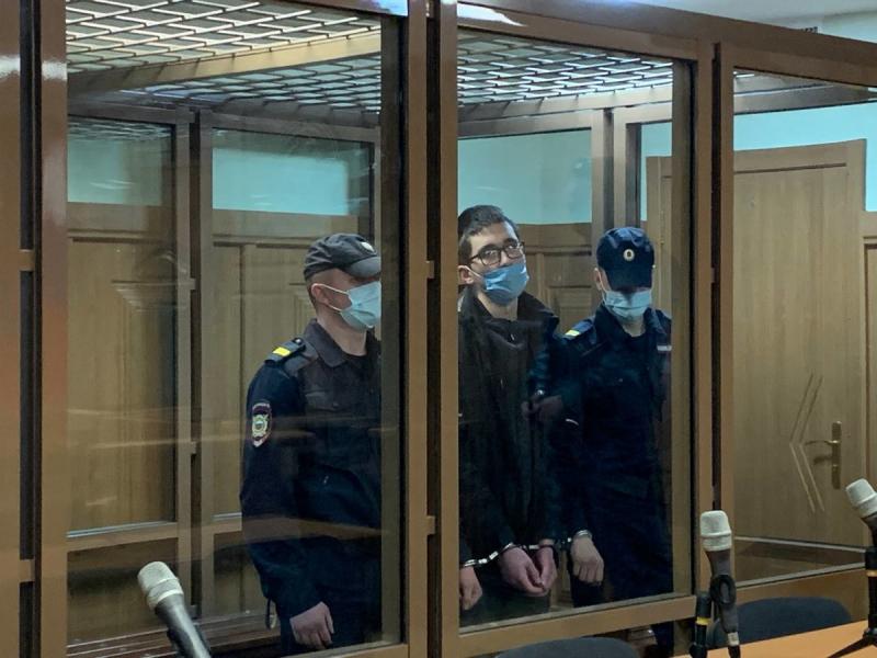 Казанский стрелок Ильназ Галявиев с полицейскими в наручниках в клетке зала суда