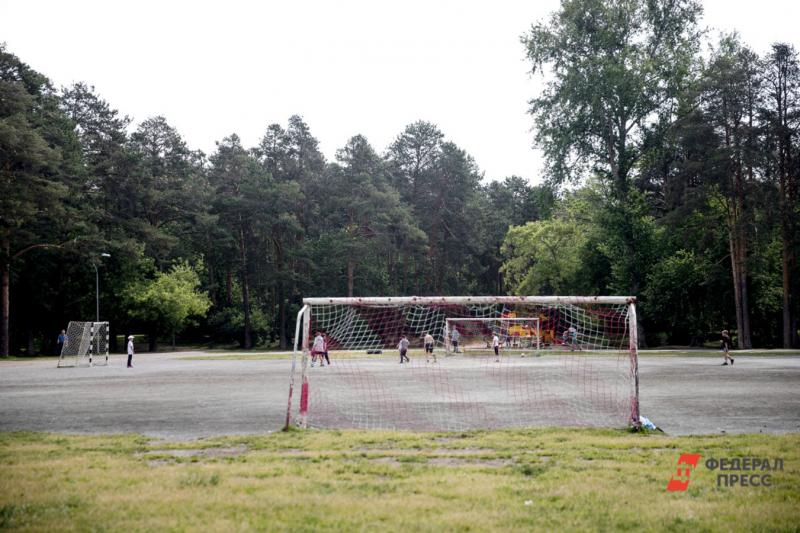 Футбольные ворота на поле летом с травой и асфальтом