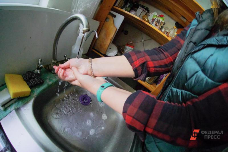 Женщина моет руки в раковине