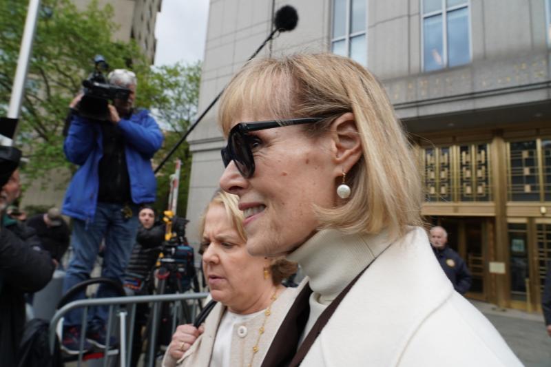 Телеведущая и журналист Джин Кэролл в белом пальто и темных очках перед зданием суда в США