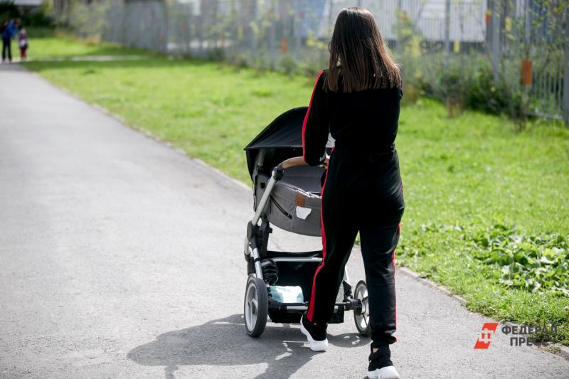 В Уфе женщина в черном костюме гуляет с детской коляской