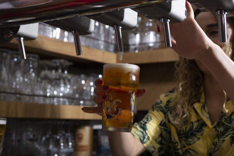 Женщина наливает разливное пиво из крана