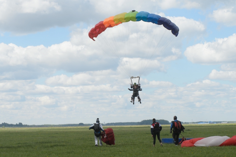 Тандем парашютистов приземляется на поле