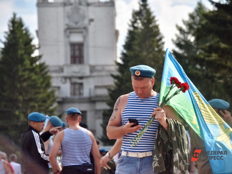 Десантник в день ВДВ с флагом и гвоздиками