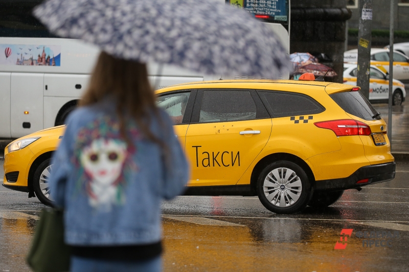 Девушка с зонтом на фоне такси во время грозы и дождя