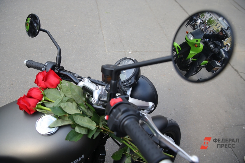 Цветы лежат на руле мотоцикла на поминках Сергея Доренко