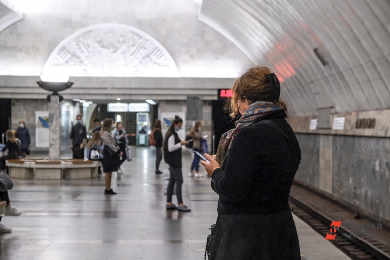 Женщина со смартфоном на станции метро