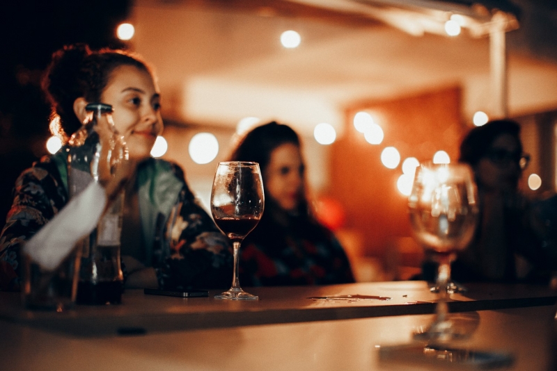 Девушки выпивают красное вино в баре