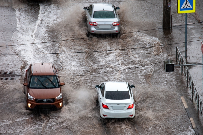 Машины едут по затопленной дороге