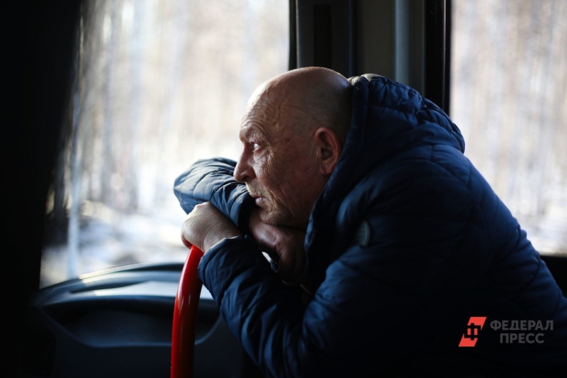 Пожилой мужчина с тростью смотрит в окно