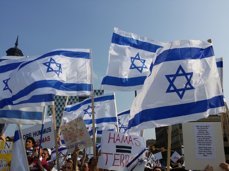 Люди на демонстрации с флагами Израиля