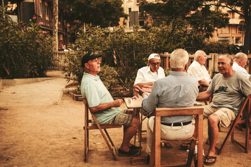 Пожилые мужчины сидят за столом