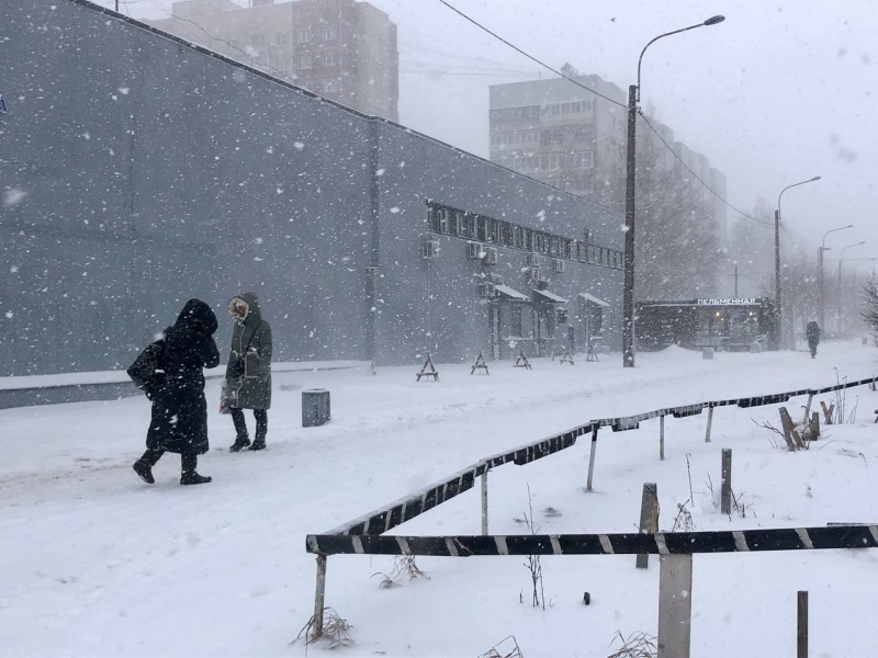 Люди идут по городу во время метели