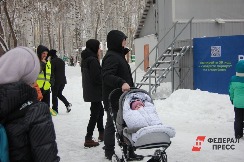 Молодая семья гуляет с ребенком зимой