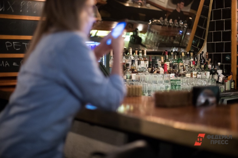 Женщина на фоне полок с алкоголем в баре
