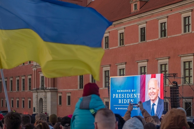 флаг украины на фоне экрана с изображением джо байдена