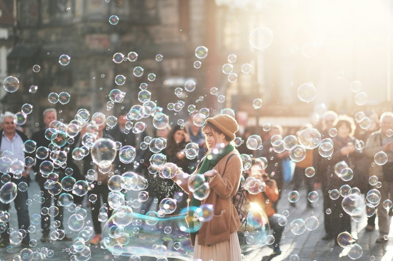 Девушка радуется мыльным пузырям