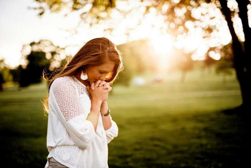 Девушка христианка молится в лесу