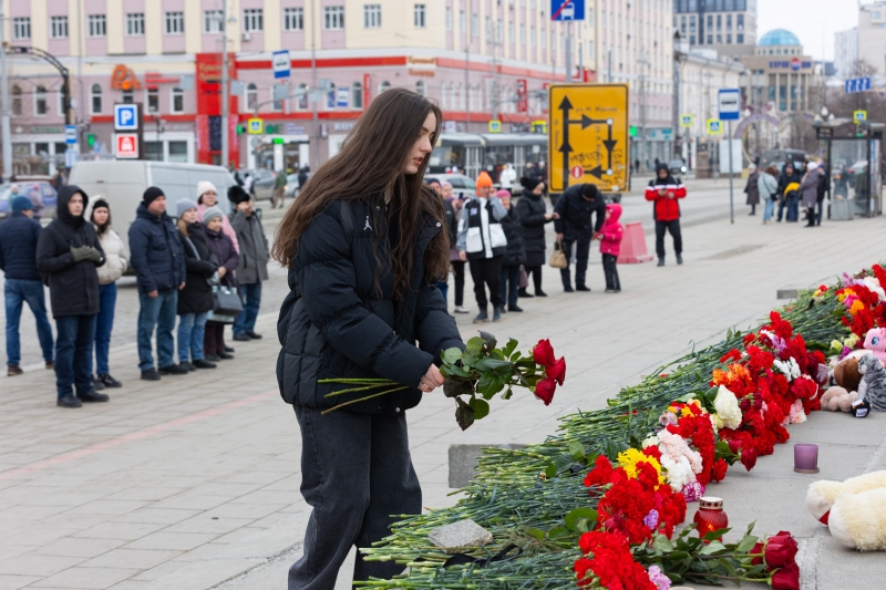 Девушка кладет цветы в память о жертвах теракта