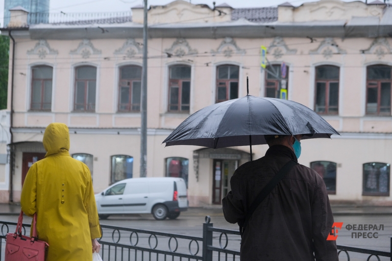 Люди идут по улице под дождем