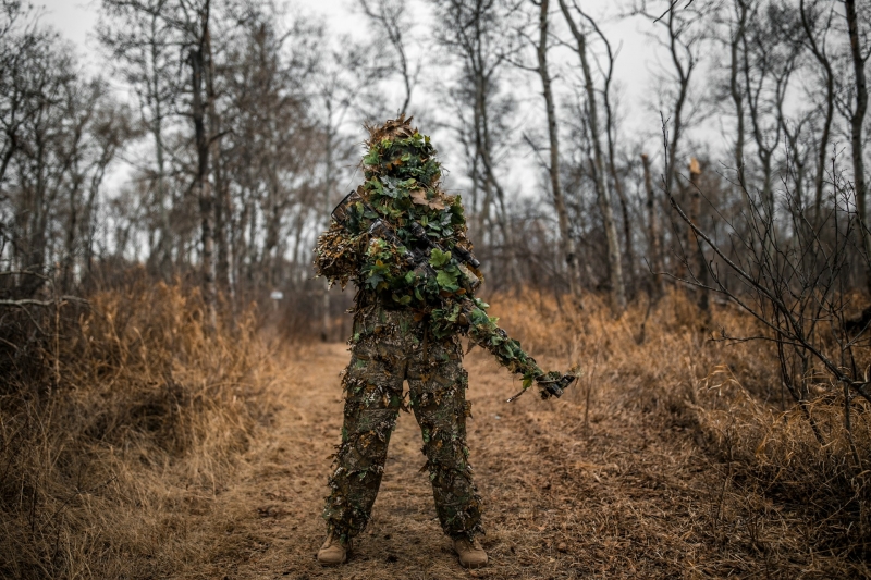 Военный стоит с оружием в руках