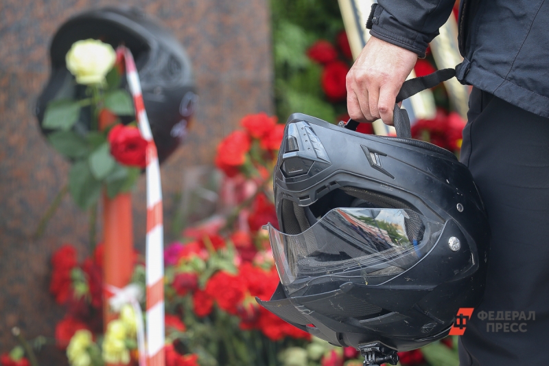 Мотоциклист держит шлем