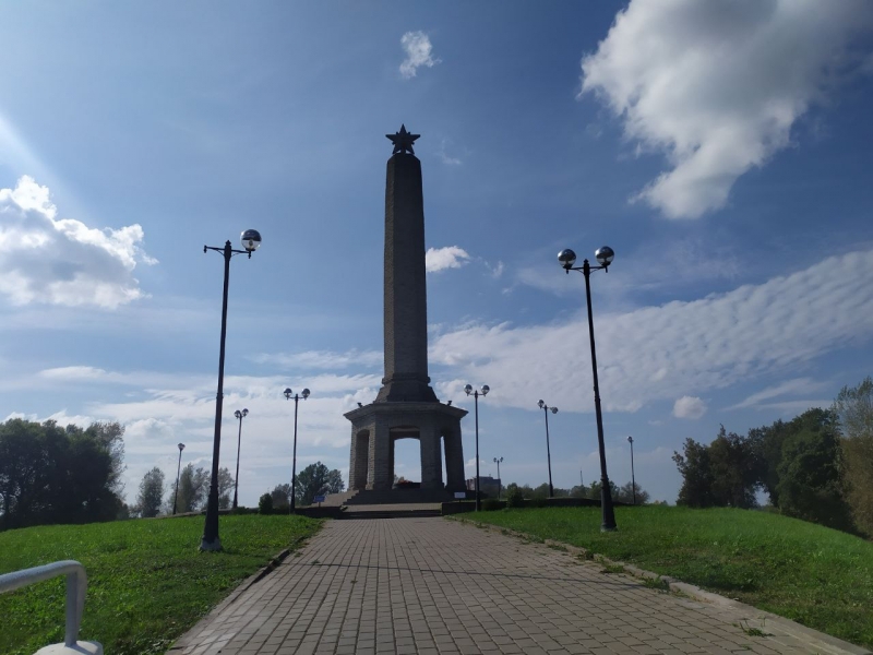 Обелиск высотой 26 м расположен центре Великих Лук, на левом берегу реки Ловать, на восточном бастионе крепости