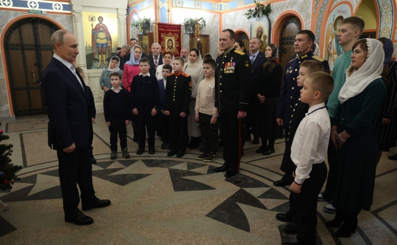 Рядом с Путиным находились военные в парадной форме с наградами, а также их супруги и дети