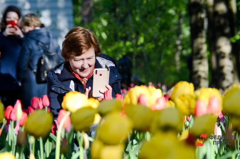 Женщина фотографирует цветы