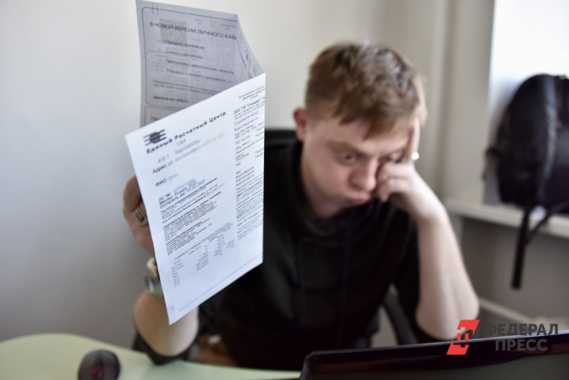 Человек смотрит на платежку ЖКХ
